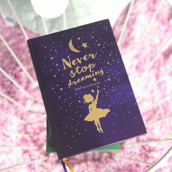 nachtblaues Traumtagebuch mit goldenen Akzenten am Cover "Never stop dreaming"